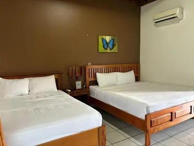 two beds in a room with two beds sidx sidx sidx at Arenal Poshpacker Boutique Urban Tropical Hotel in Fortuna