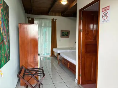 a room with a bed and a window and a door at Arenal Poshpacker Boutique Urban Tropical Hotel in Fortuna