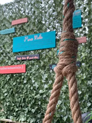 a brown rope tied to a wall with signs at Point Break Santa Teresa in Santa Teresa Beach