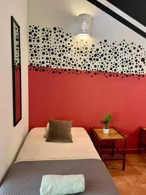 a bedroom with a bed and a red wall at Point Break Santa Teresa in Santa Teresa Beach