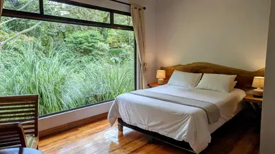 a bedroom with a bed and a large window at Olingo Monteverde - Stunning Home Near Adventure Parks in Monteverde Costa Rica