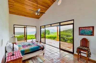 a bedroom with a bed and sliding glass doors at Serenity House Panoramic Views And Swimming Pool, in El Castillo de la Fortuna