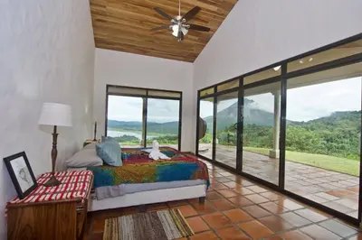 a bedroom with a bed and large glass windows at Serenity House Panoramic Views And Swimming Pool, in El Castillo de la Fortuna