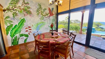 a dining room with a table and chairs and a mural at Serenity House Panoramic Views And Swimming Pool, in El Castillo de la Fortuna