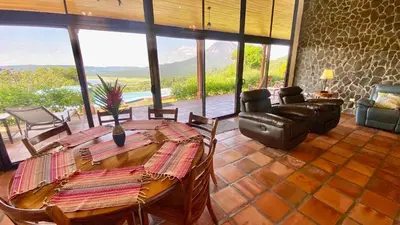 a living room with a wooden table and chairs at Serenity House Panoramic Views And Swimming Pool, in El Castillo de la Fortuna