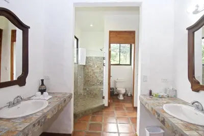 a bathroom with two sinks and a shower at Serenity House Panoramic Views And Swimming Pool, in El Castillo de la Fortuna
