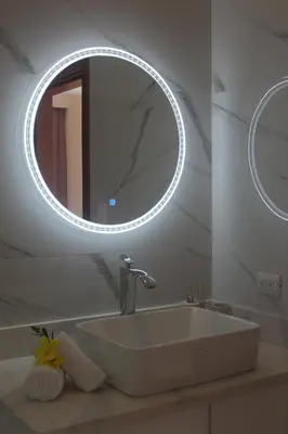 a bathroom with a sink and a round mirror at Casa Coco de Mer 1 in Tamarindo