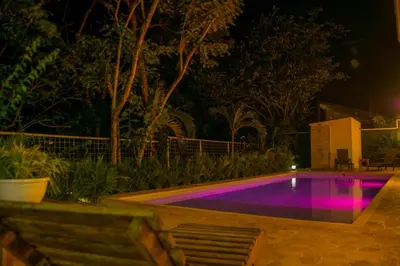 a pool with purple lighting in a backyard at night at Casa Coco de Mer 2 in Tamarindo