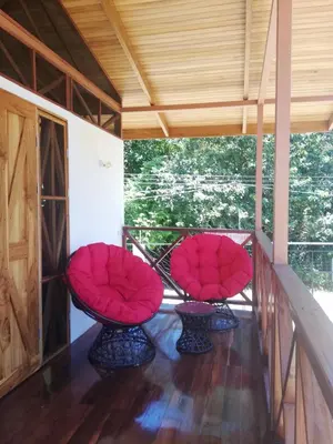 two red chairs sitting on a porch at Ibiza Tropical Beach Villas in Uvita