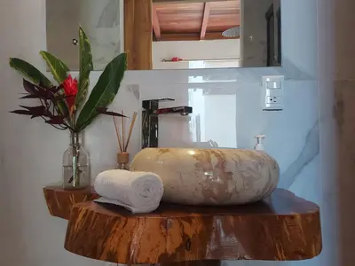 a bathroom with a large stone sink on a counter at Ibiza Tropical Beach Villas in Uvita
