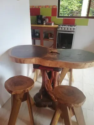 a wooden table and two stools in a kitchen at Ibiza Tropical Beach Villas in Uvita