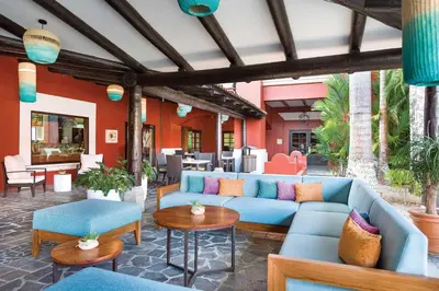 a patio with a blue couch and chairs and tables at Marriott Vacation Club at Los Sueños in Jacó