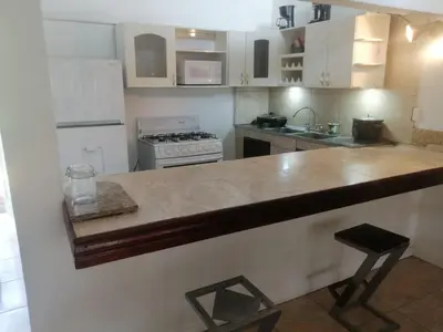 a kitchen with white cabinets and a wooden counter top at El Castillo Monte Campana in Puntarenas