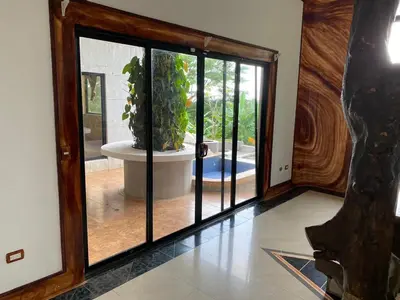 a room with a large glass door with a potted plant at El Castillo Monte Campana in Puntarenas