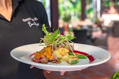 a person is holding a plate of food at Sunset del Mar Beach Resort in Esterillos Este