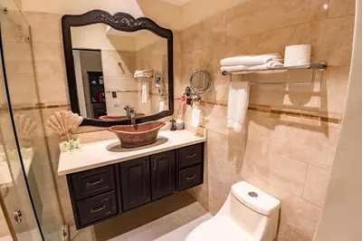 a bathroom with a sink and a mirror and a toilet at Sunset del Mar Beach Resort in Esterillos Este