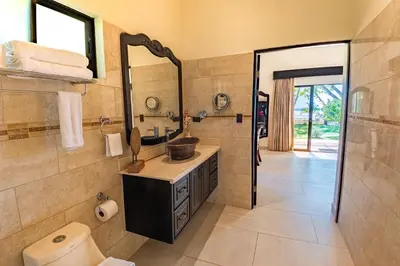 a bathroom with a sink and a mirror at Sunset del Mar Beach Resort in Esterillos Este