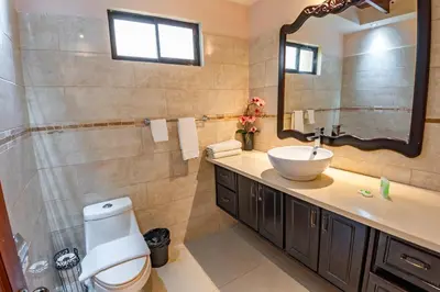 a bathroom with a toilet and a sink and a mirror at Sunset del Mar Beach Resort in Esterillos Este