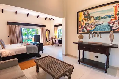a bedroom with a bed and a table in a room at Sunset del Mar Beach Resort in Esterillos Este