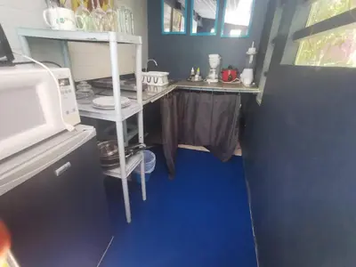 a small kitchen with a blue floor and a microwave at CHEZ NOUS in Carrillo