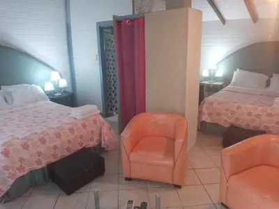 a bedroom with two beds and an orange chair at CHEZ NOUS in Carrillo