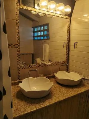 a bathroom with two sinks in front of a mirror at CHEZ NOUS in Carrillo