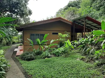 a small house in the middle of a garden at Iguana Libre in Dominical