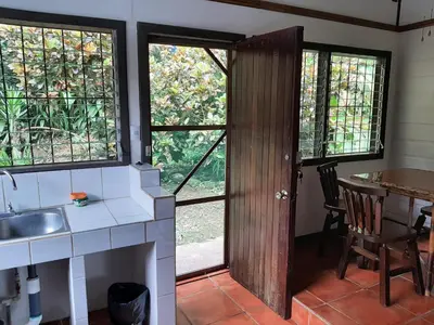 a kitchen with a sink and a table and windows at Iguana Libre in Dominical