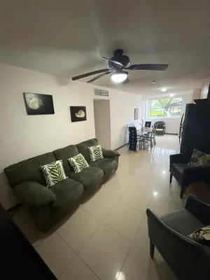 a living room with a couch and a ceiling fan at Casa apartamento Costa Linda jaco in Jacó