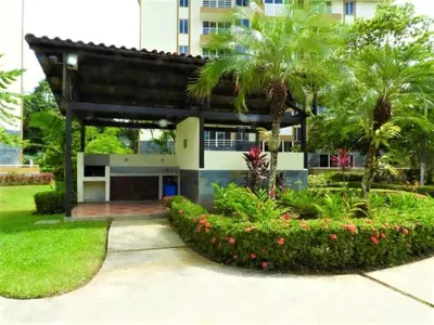 a building with palm trees and a courtyard at Casa apartamento Costa Linda jaco in Jacó