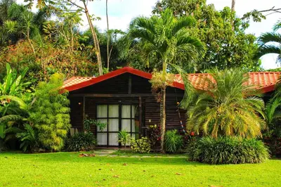 a small wooden house with a red roof at Casona Rústica & Bungalow in Fortuna