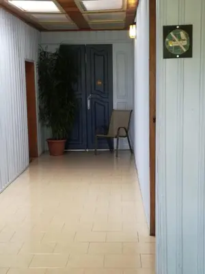 a hallway with a blue door and a chair at Casona Rústica & Bungalow in Fortuna