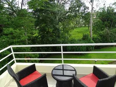 two chairs and a table on a porch with a view at 3Room Jaco Condos in Jacó