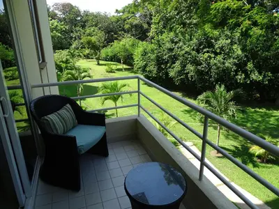 a balcony with a chair and a table at 3Room Jaco Condos in Jacó