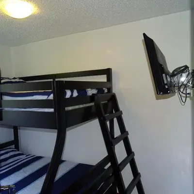 a bunk bed with a television on a wall at 3Room Jaco Condos in Jacó