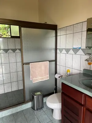 a bathroom with a toilet and a sink and a shower at Mango Tree Villas in Coronado