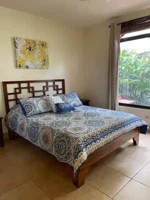 a bedroom with a large bed with a window at Mango Tree Villas in Coronado