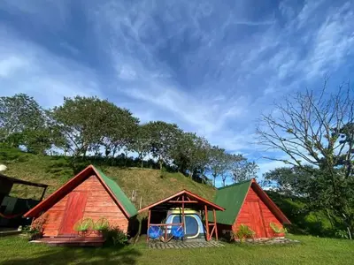 two houses with a grassy hill on top of them at Sunset Inn Arenal B&B in Fortuna