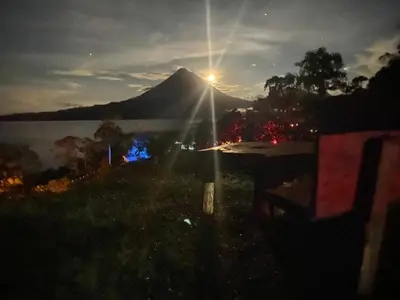 a view of a mountain with the sun shining on it at Sunset Inn Arenal B&B in Fortuna