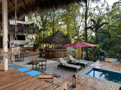 a resort with a pool and a deck with chairs and tables at La Sana Surf Hotel, Playa Carmen in Santa Teresa Beach