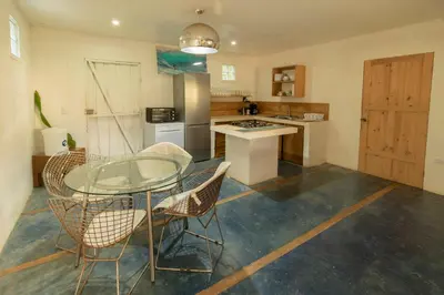 a kitchen with a glass table and chairs at La Sana Surf Hotel, Playa Carmen in Santa Teresa Beach