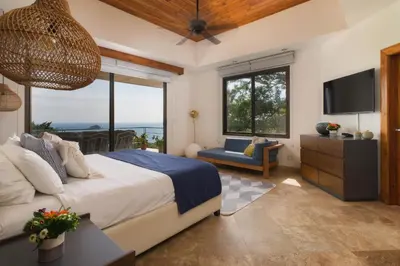 a bedroom with a large bed and a television at Casa Anjali by Sandglass in Manuel Antonio