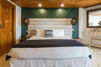 a bedroom with a large bed and a green wall at Casa Anjali by Sandglass in Manuel Antonio
