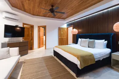 a bedroom with a bed and a tv and a couch at Casa Anjali by Sandglass in Manuel Antonio