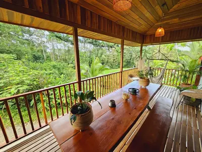 a porch with a wooden table with potted plants on it at Villa Cocos la Fortuna in Fortuna