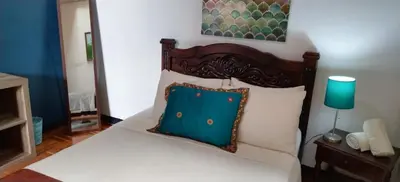 a bedroom with a bed with a blue pillow on it at Lajuela BnB & Hostel in Alajuela City