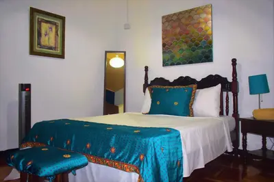 a bedroom with a bed with a blue comforter at Lajuela BnB & Hostel in Alajuela City
