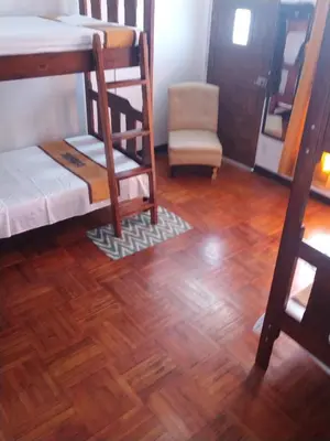 a room with bunk beds and a wooden floor at Lajuela BnB & Hostel in Alajuela City