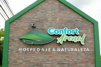 a sign on the side of a brick building at Confort Arenal in Fortuna