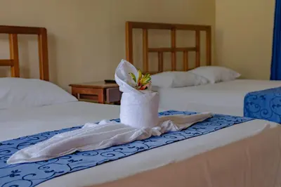 a hotel room with two beds with towels on them at Confort Arenal in Fortuna